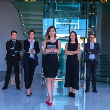 A confident business team posing in a modern office lobby.
