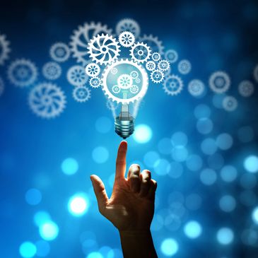 Hand touching a glowing light bulb with gears, symbolizing innovation and ideas.