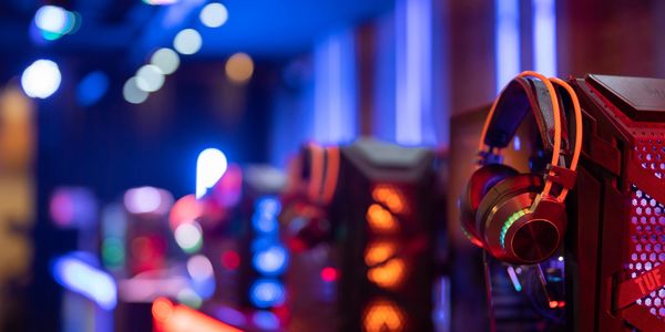 Gaming headphones on a computer tower with colorful LED lights.