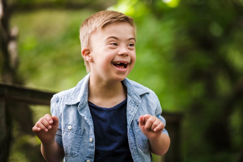 A Portrait of a little boy with down syndrome while playing in a park