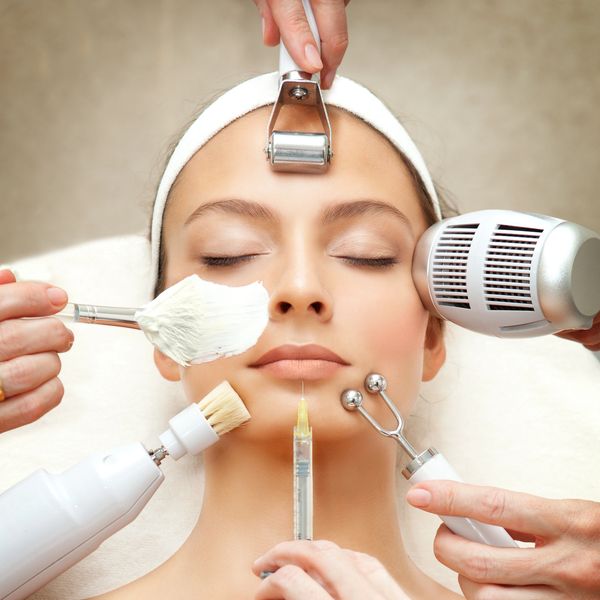 Woman receiving multiple facial treatments simultaneously at a spa.