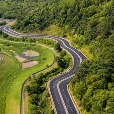 A winding road through lush green hills and fields.
