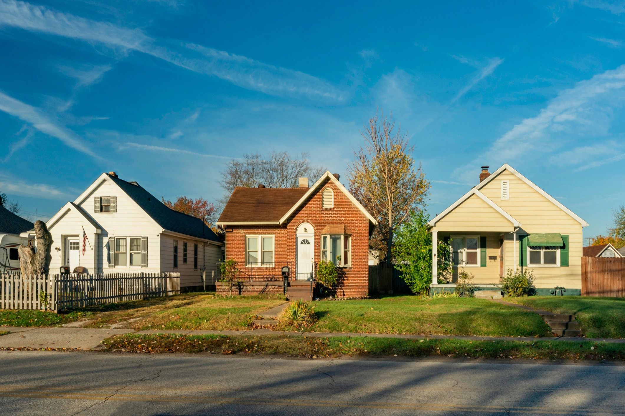 Three small houses under a clear blue sky.