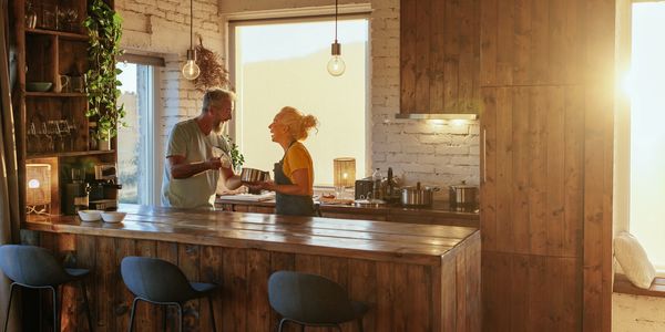 Couple enjoying kitchen conversation during sunset.