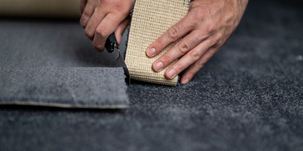 Cutting carpet with a utility knife.