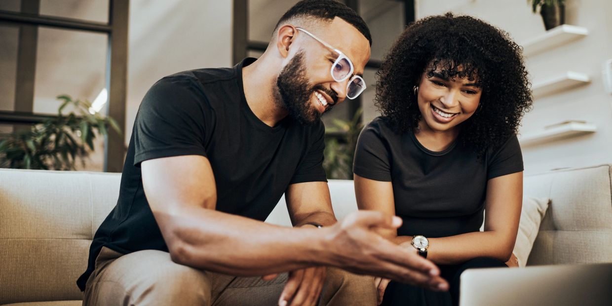 Two people happily discussing something on a laptop.