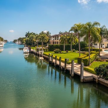 Waterfront homes with private docks and boats on a sunny day.
