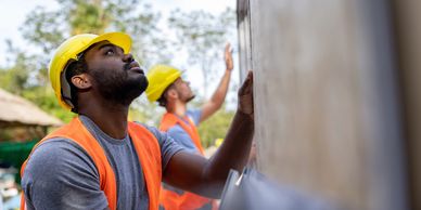 Construction workers inspecting a wall.