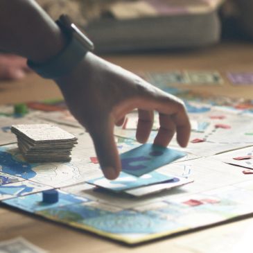 Hand moving a card on a board game.