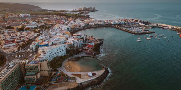 A coastal town with a harbor and boats on calm water at dusk.
