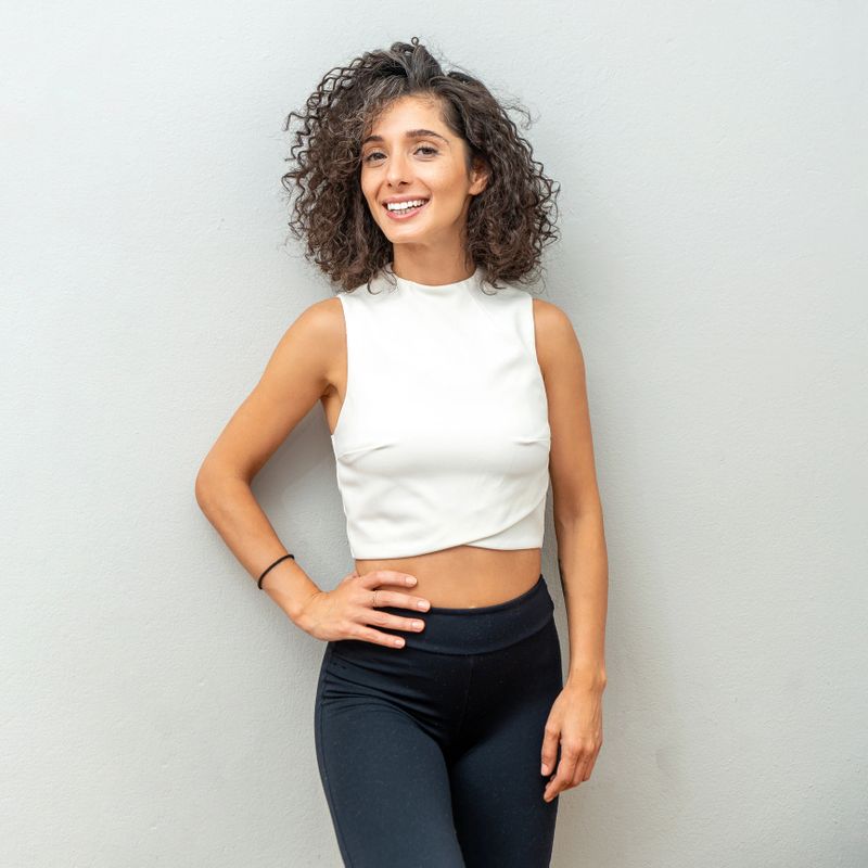 Portrait of beautiful curly-haired woman in front of the wall