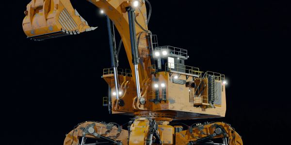 Large yellow excavator with bucket attachment illuminated at night.