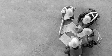 Construction workers reviewing plans at a site.