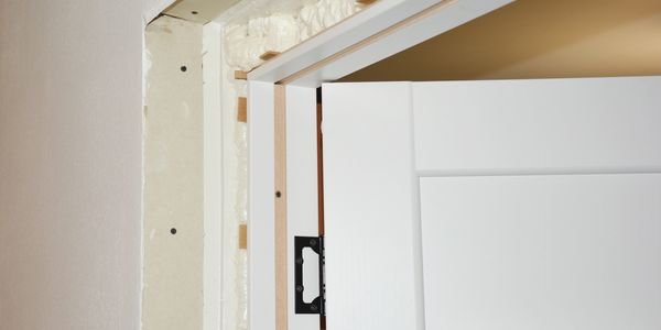 Close-up of a white door frame under construction with foam insulation.