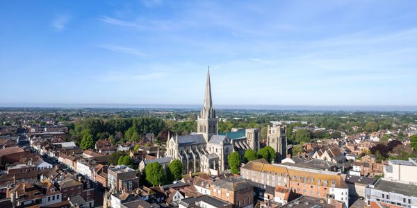Aerial view of a historic town with a large cathedral and surrounding buildings.