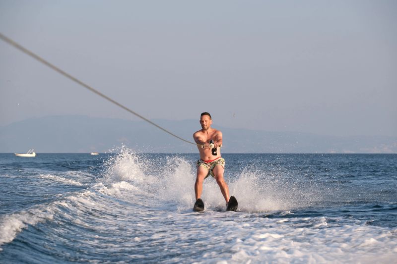 Man waterskiing on sea at summer