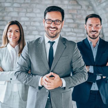 Confident business team smiling and posing in suits.