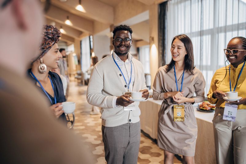 Diverse group of people, male and female business people talking during coffee break at the convention center.