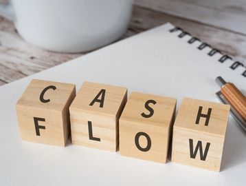 Wooden blocks spelling 'CASH FLOW'.