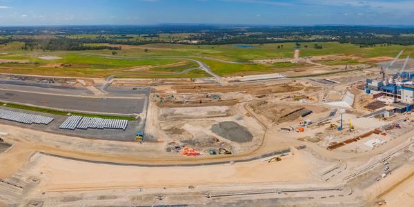 Aerial view of a large construction site with earthworks and machinery.