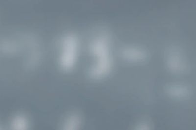 Blurred white text on a grey background.