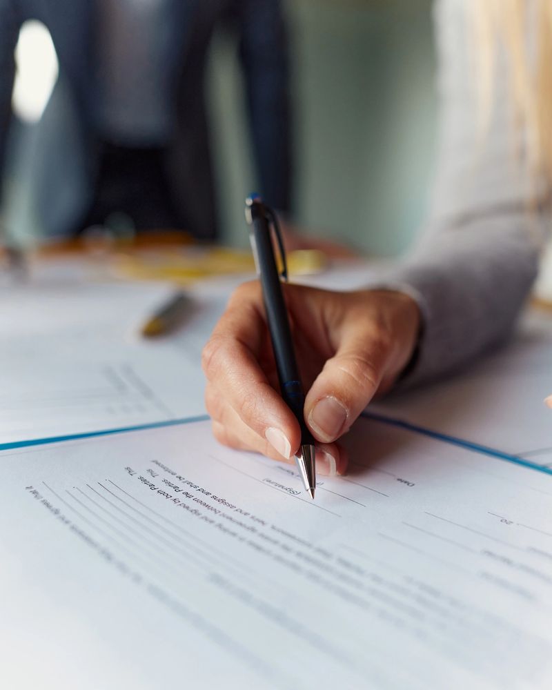 Close up of unrecognizable woman signing a contract.