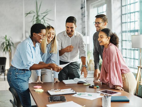Diverse team collaborating around a table in a bright modern office — sharing ideas