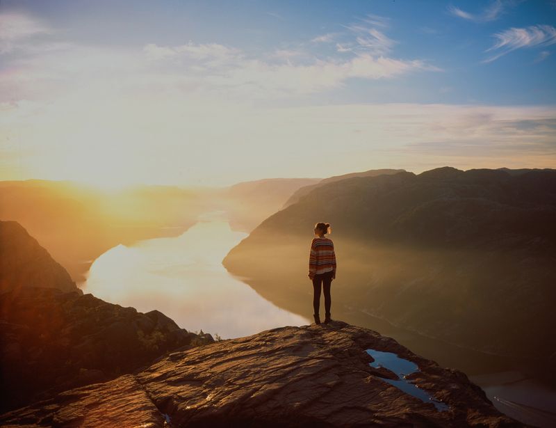 Young Caucasian woman hiking in mountains on the background of Lysefjorden