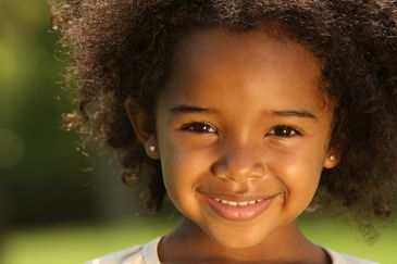 Young smiling and happy girl with both ears pierced with studs.
