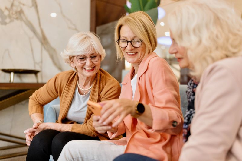 Three senior female friends enjoying vacation time in hotel cafe