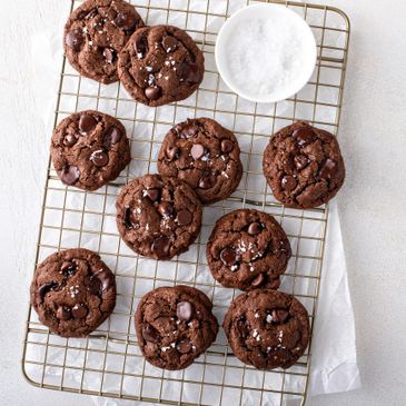 Chocolate cookies with sea salt on a cooling rack.