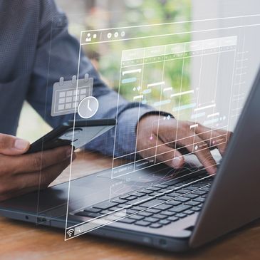 Person managing project schedule on laptop and smartphone with digital timeline interface.