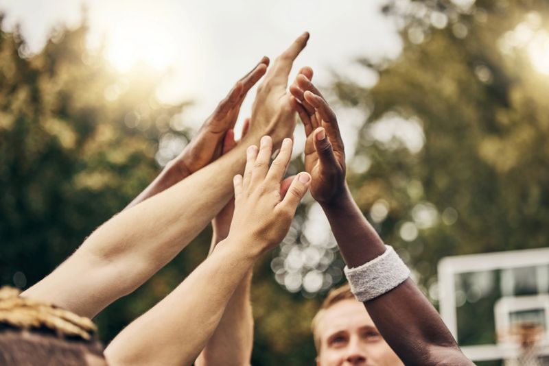 Basketball, hands and team of men high five for outdoor game. Success, diversity and victory in sports for boys goal. Teamwork, diversity and support, friends on basketball court together with coach.