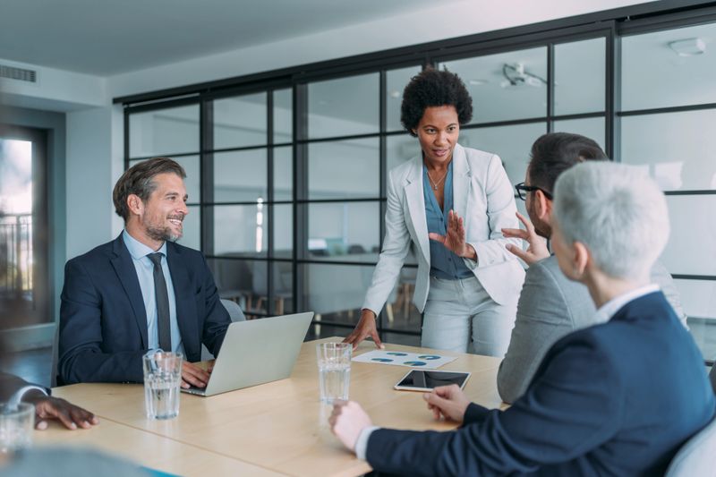 Shot of a businesswoman giving a presentation in the office board room. Group of business persons in business meeting. Group of entrepreneurs on meeting in board room. Corporate business team on meeting in the office.