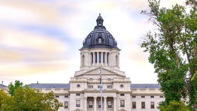 South Dakota State Capitol building with a grand dome and surrounding greenery.