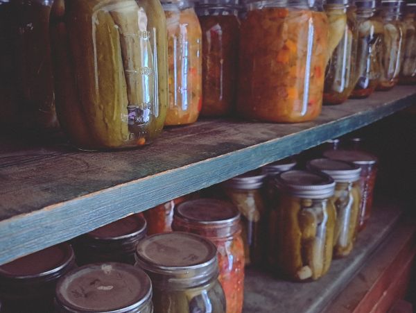 Shelves stocked with jars of pickled vegetables and preserves.