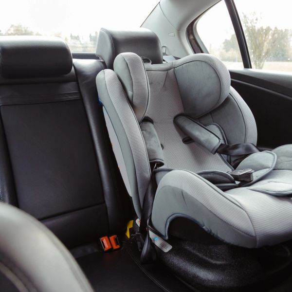 Gray child car seat installed inside a car.