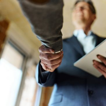 Two people shaking hands indoors.