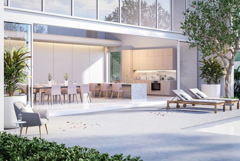 Modern style concrete terrace with dining room and kitchen in modern style white house background 3D render turn on the lights inside the building,decorated with gray furniture