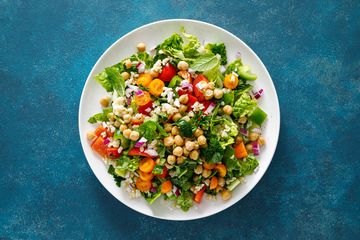 Colorful chickpea and vegetable salad on a white plate.