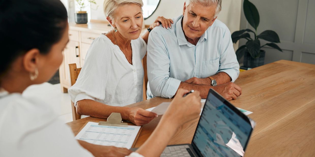 Couple consulting with a professional at a desk.