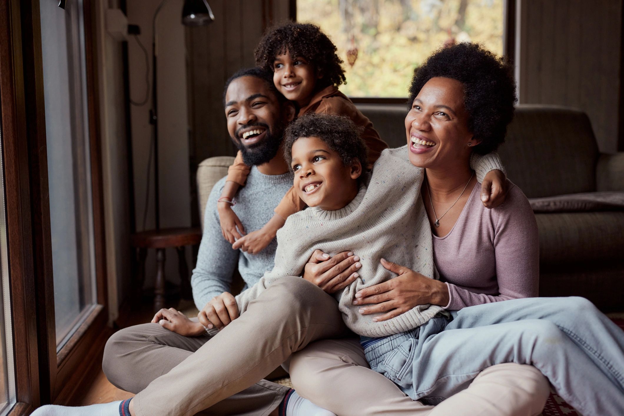 Family with two children relaxing together at home | Family First Financial
