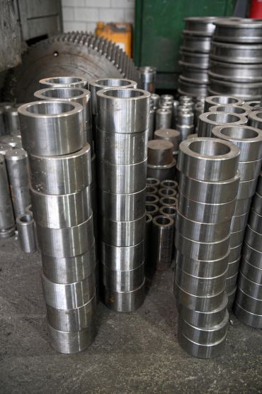 Stacks of metal cylindrical components in a workshop.