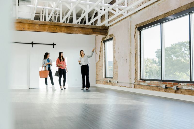 The mature adult female real estate broker points out the special features of the office rental to two female clients.