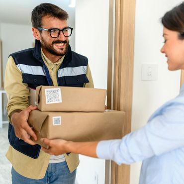 Delivery man handing over packages to a woman.