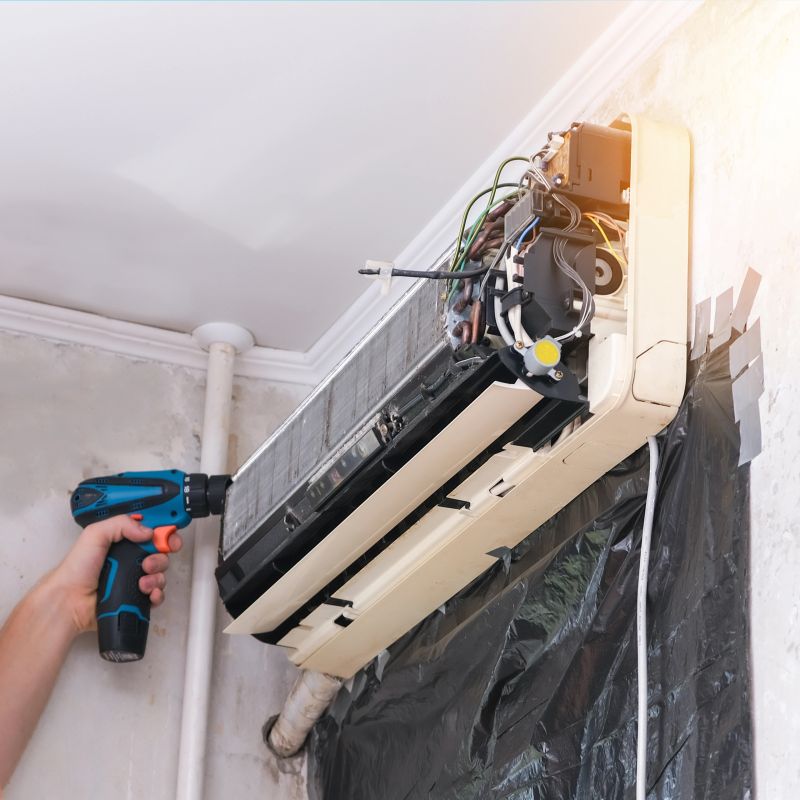 A man disassembles an air conditioner for repair and cleaning. Split system maintenance.