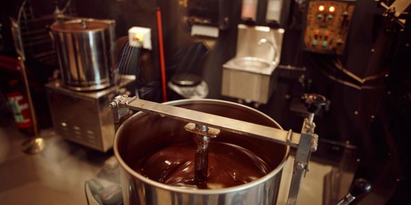 Chocolate being melted and mixed in a large industrial machine.