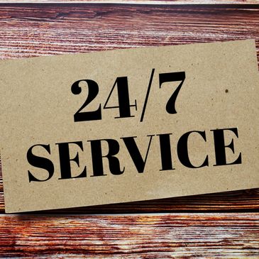 Card with 24/7 service text on wooden background.