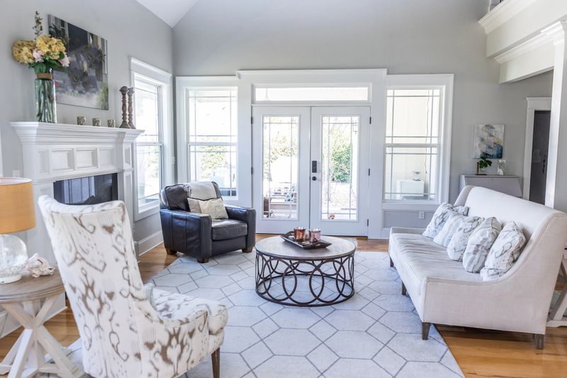 A light and bright open concept living room den with vaulted ceilings in a new construction house with a set of double glass doors to the patio.
