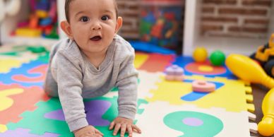 Baby crawling on colorful foam play mat.